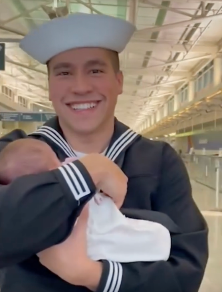 Navy Sailor holding his newborn daughter